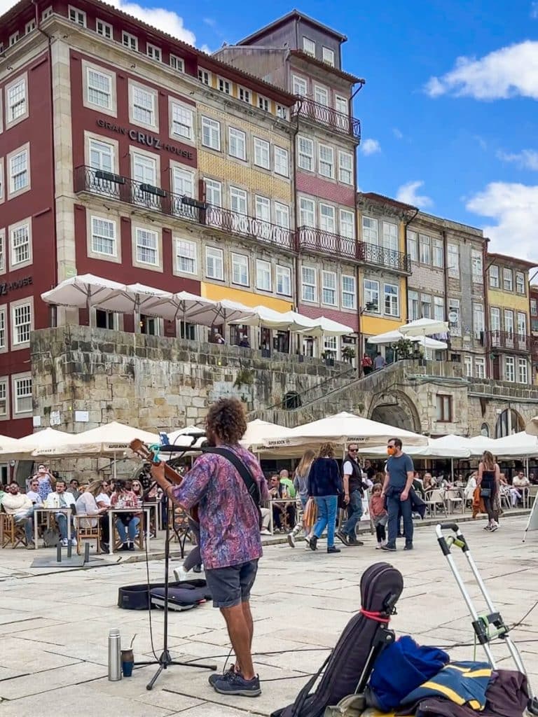 Busker entertaining a crowd of outdoor diners on the Ribeira in Porto, portugal