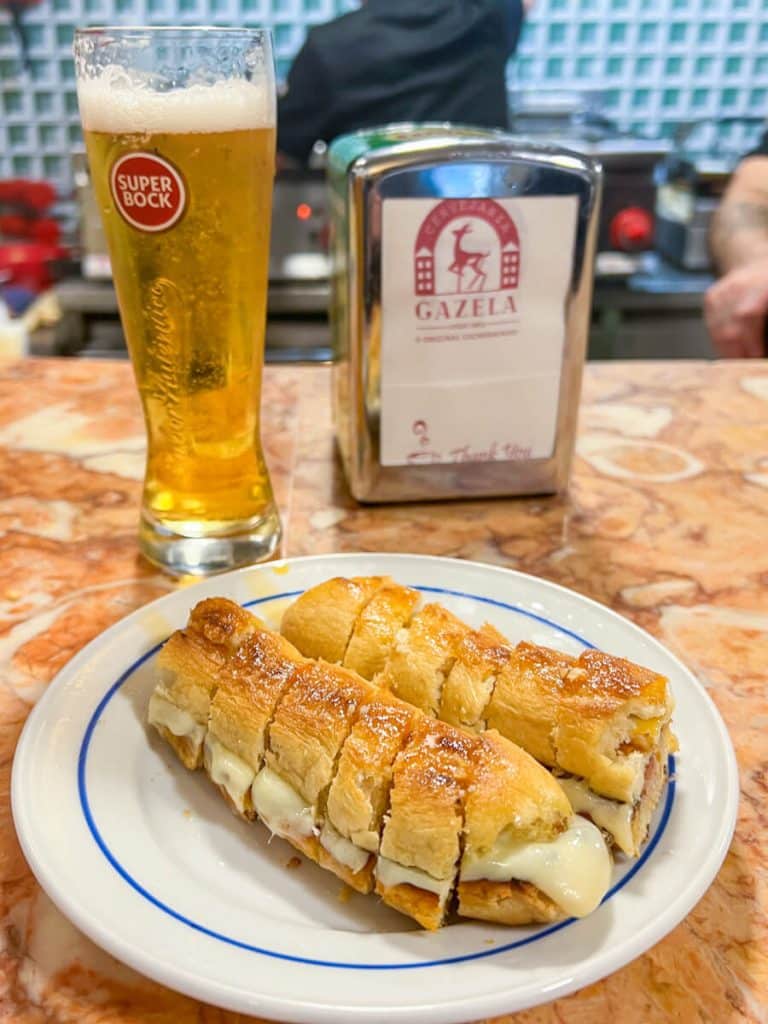 Cachorrinho (special Portuguese hot dog) and a pint of Super Bock at the counter at Gazela in Porto, Portugal