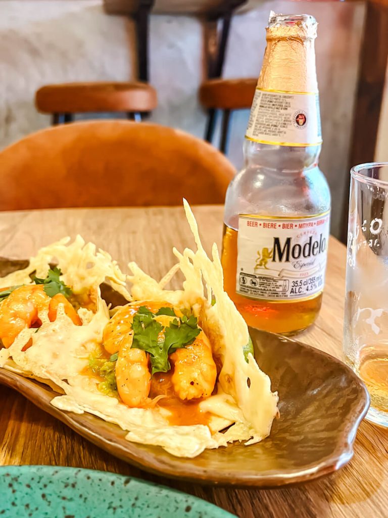 a plate of shrimp tacos and a bottle of Modelo (Mexican beer)