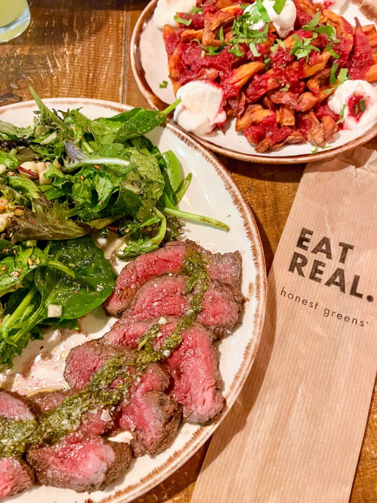 Plate of steak chimichurri, salad and sweet potato fries from Honest Greens