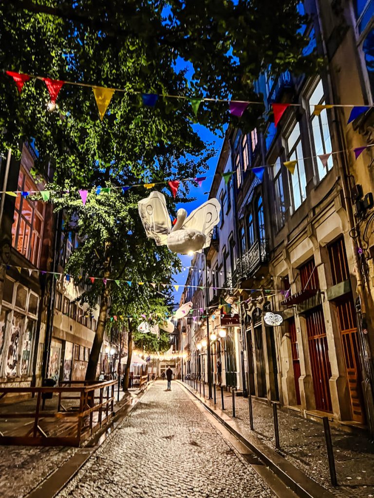Empty cobblestone street with string lights hovering overhead