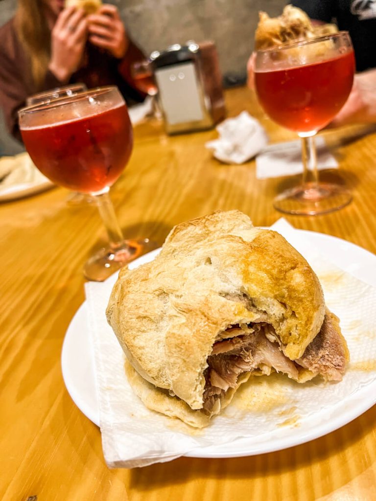 Bifana (Portuguese pork sandwich) and a glass of red sparkling wine