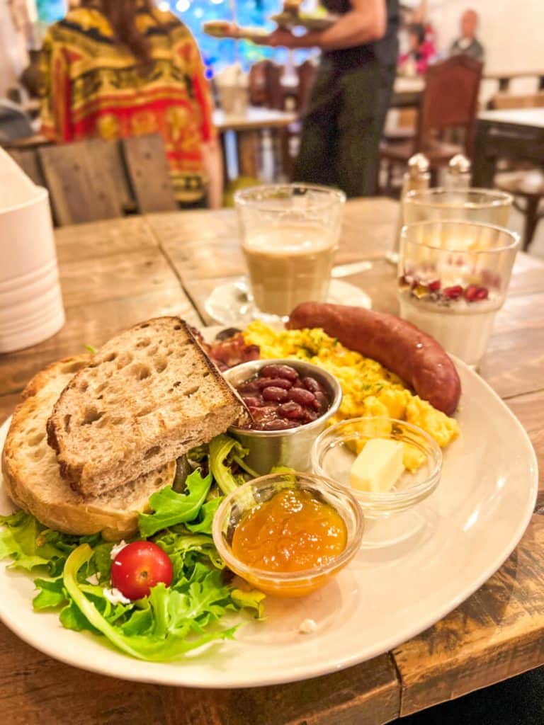 Breakfast plate of bread, beans, eggs, sausage and jam