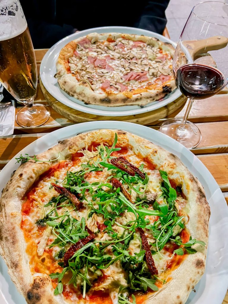 Table with 2 pizzas and drinks