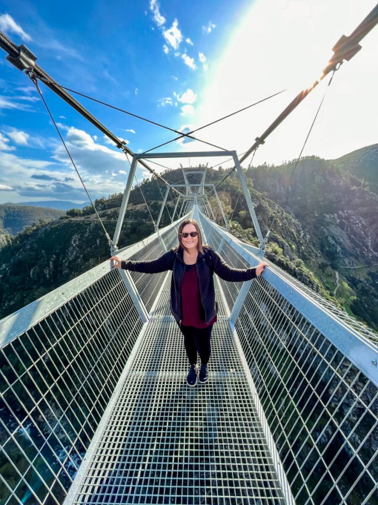 Girl standing on Arouca 516 metal suspension bridge in Portugal